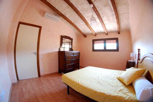Schlafzimmer mit einem Bett, einer Kommode und einem Spiegel in der Unterkunft Ca lHorténsia in Rourell