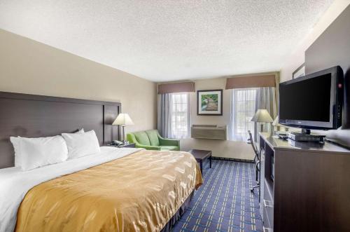 a hotel room with a bed and a flat screen tv at Quality Inn in Waynesboro