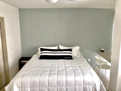 a bedroom with a bed with a black and white pillow at Beautiful Apartment fully equipped AC 6 people 3 Bedrooms Wifi in Manzanillo