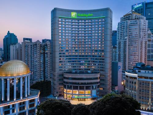 un grand bâtiment avec un panneau en haut dans l'établissement Holiday Inn Shanghai Nanjing Road, an IHG Hotel, à Shanghai