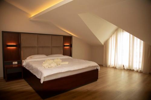 1 dormitorio con 1 cama grande y toallas blancas. en Hotel Oferta en Prizren