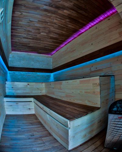 a wooden sauna with a purple light on the ceiling at Elexus Predeal in Predeal