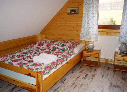 Un dormitorio con una cama con flores. en Domki Górskie Zacisze, en Koniaków