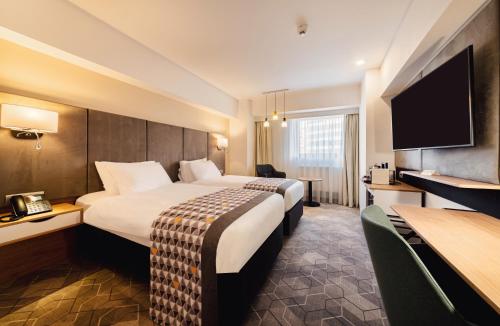 a hotel room with two beds and a flat screen tv at Holiday Inn Bucharest - Times by IHG in Bucharest