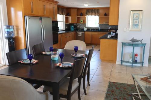 a kitchen with a table with chairs and a refrigerator at Tranquility in Paradise - Sugarloaf - 17 miles to Key West in Sugarloaf Shores
