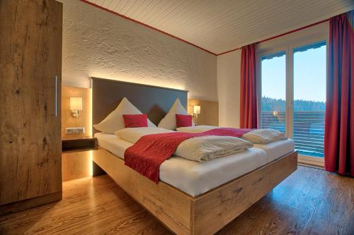 1 dormitorio con 1 cama grande y ventana grande en Natur- und Wanderhotel am Steinbachtal, en Bad Kötzting