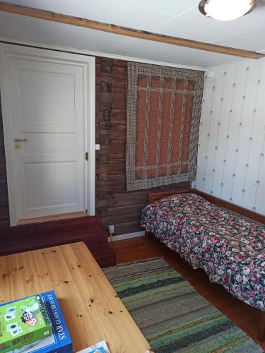 a bedroom with a bed and a door and a table at Laukkumäki farm in Iisalmi