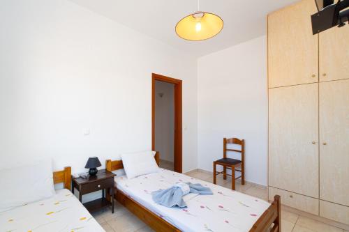 ein Schlafzimmer mit 2 Betten und einem Stuhl darin in der Unterkunft BOGGI in Goúdhouros