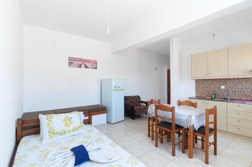 a living room with a bed and a table and a kitchen at BOGGI in Goúdhouros