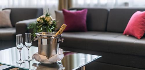 a living room with a couch and a table with wine glasses at Hotel Fontana Vrnjačka Banja in Vrnjačka Banja