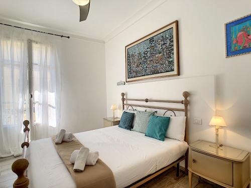 um quarto branco com uma cama grande e almofadas azuis em Nestor&Jeeves - LAVINIA - Central - Close sea em Nice