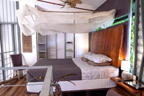 a bedroom with a bed with a canopy at Perezoso Villa. Jurassic Park loft in the jungle in Puerto Viejo