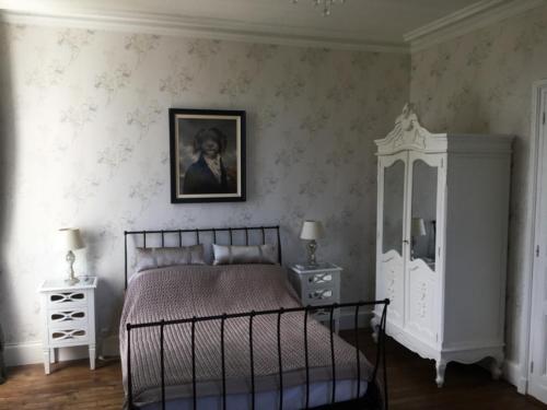 a bedroom with a bed and a picture on the wall at Stunning Chateau on the river bank in Saint Astier in Saint-Astier