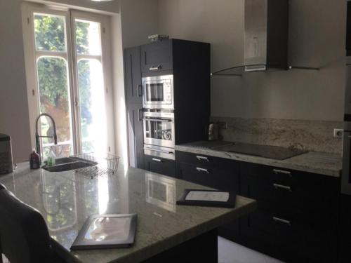 a kitchen with a counter with a sink and an oven at Stunning Chateau on the river bank in Saint Astier in Saint-Astier