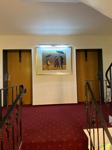 a hallway with two doors and a picture on the wall at Hotel Pension Berghaus Sieben in Bad Laasphe