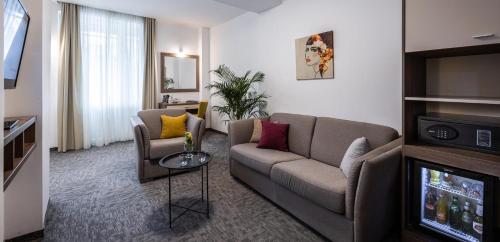 a living room with a couch and a tv at Hotel Fontana Vrnjačka Banja in Vrnjačka Banja