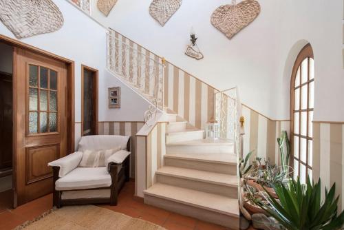 a staircase in a home with a chair and a stair case at Troia Beach Getaway in Troia