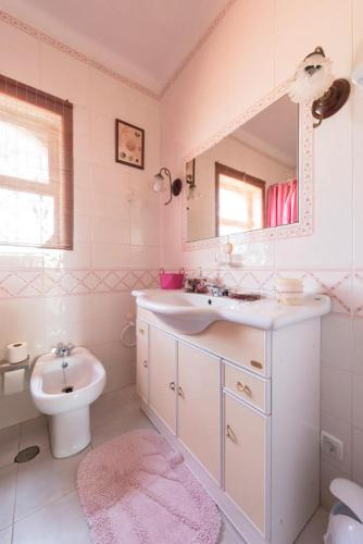 a bathroom with a sink and a toilet and a mirror at Troia Beach Getaway in Troia