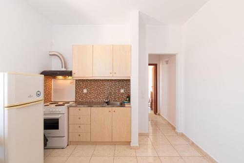 a kitchen with white appliances and a white refrigerator at BOGGI in Goúdhouros
