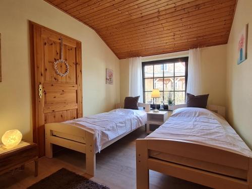 a bedroom with two beds and a window at Haus Seeheim in Böhl