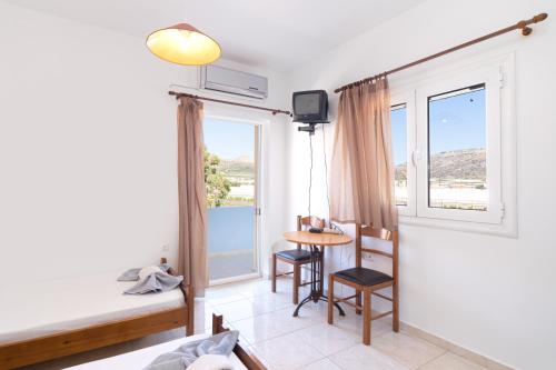 a room with a bed and a table and a window at BOGGI in Goúdhouros