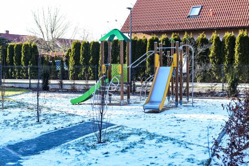 einen Spielplatz in einem schneebedeckten Park in der Unterkunft Apartament VILLA PARK przy plaży z widokiem na jezioro, taras 50 m2 in Ostróda