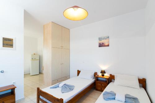 a bedroom with two beds and a cabinet at BOGGI in Goúdhouros