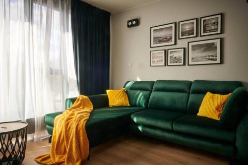 ein grünes Sofa mit gelben Kissen im Wohnzimmer in der Unterkunft EASY RENT Apartments - Diamond in Lublin