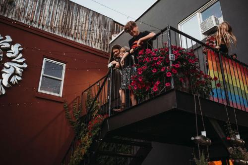 a group of people standing on a balcony with flowers at The Haven Hostel in Thunder Bay