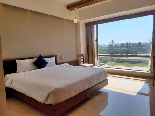 a bedroom with a large bed and a large window at VITS The Somnath Gateway in Somnath