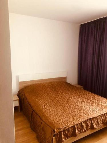 a bedroom with a bed with a brown bedspread at COLORFUL PARADISE in Piatra Neamţ
