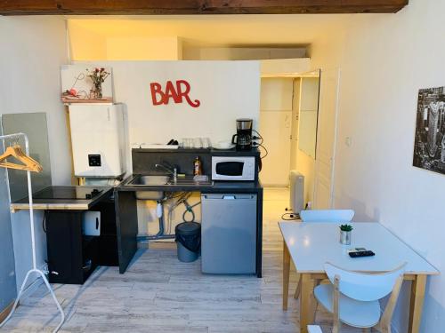 une cuisine avec une table et un panneau de bar sur le mur dans l'établissement Mirabeau Studio, à Aix-en-Provence