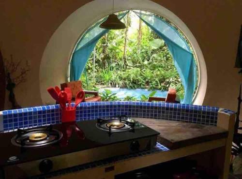 een keuken met een fornuis en een groot raam bij Casa Corazon del Mar in Puerto Viejo