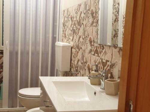 a bathroom with a white sink and a toilet at Oasi Iblea Inn in Ragusa