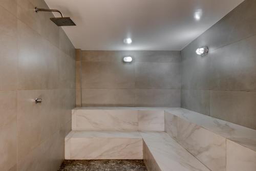 a bathroom with a tub, toilet, and shower stall at Quality Suites Vila Velha in Vila Velha
