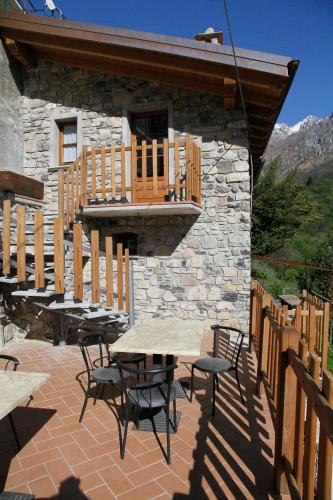 a patio with tables and chairs in front of a building at Agriturismo Crotto Di Somana in Mandello del Lario