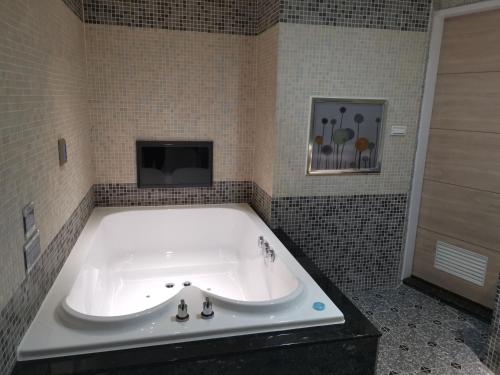 a bath tub with a tv in a bathroom at Love Story Motel in Taipei