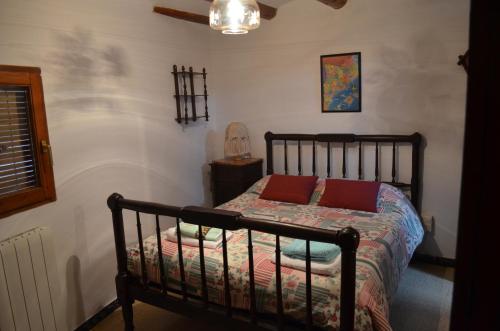 a bedroom with a bed with two red pillows at Casa Corroncui in Sant Marti de Canals
