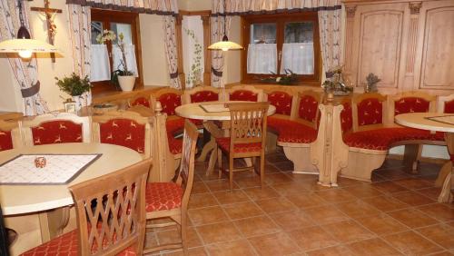 a restaurant with tables and red chairs and tables and tablesktop at Urlaub am Bauernhof Rothof in Sankt Johann im Pongau