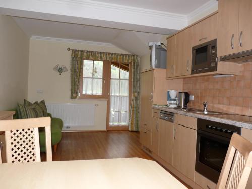 a kitchen with wooden cabinets and a table in a room at Urlaub am Bauernhof Rothof in Sankt Johann im Pongau