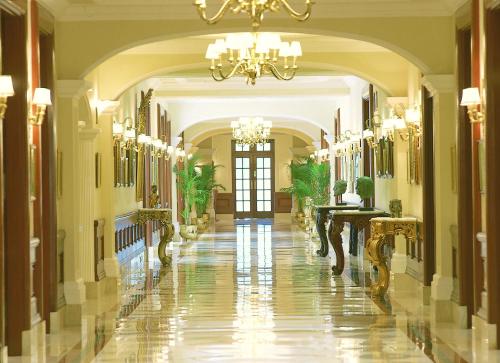 a hallway with a large mirror and a person walking in it at The Imperial, New Delhi in New Delhi