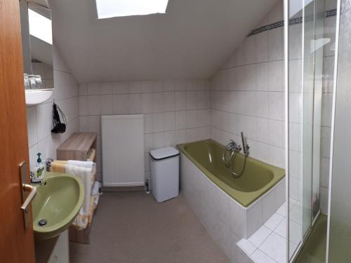 La salle de bains est pourvue d'une baignoire verte et d'un lavabo. dans l'établissement Ferienwohnung Rutz, à Ruhpolding