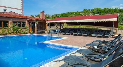 a swimming pool with lounge chairs next to a house at Studio apartment in Novalja with sea view, terrace, air conditioning, Wi-Fi (3565-4) in Novalja