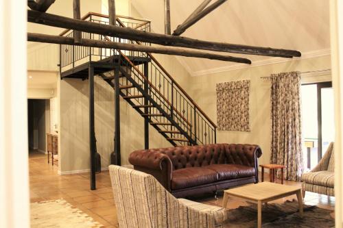 a living room with a couch and a staircase at Mount Shekinah Country Hotel in Balgowan