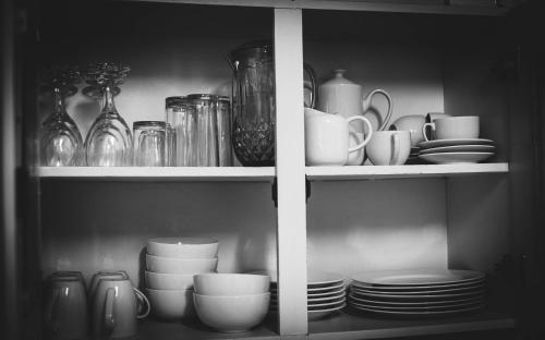 a cabinet filled with plates and cups and dishes at Manna Self Catering Guesthouse in Graskop