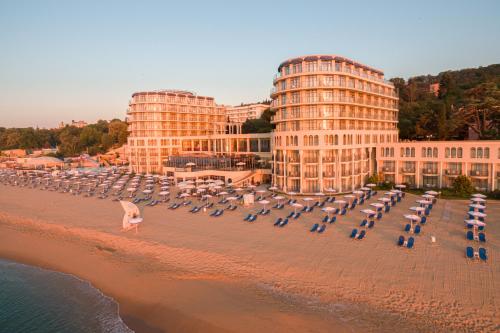 a group of umbrellas on a beach in front of buildings at Azalia Beach Hotel Balneo & SPA in St. St. Constantine and Helena