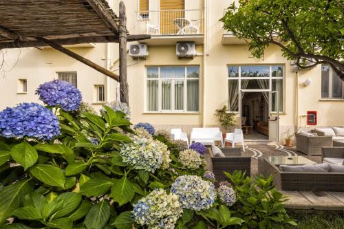 a house with a garden with purple and white flowers at Sisters Hotel in Piano di Sorrento