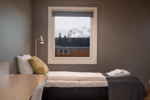 1 dormitorio con cama y ventana en Fast Hotel Svolvær, en Svolvær