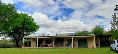 ein Haus mit einem Tisch und Stühlen im Hof in der Unterkunft El Campito de La Ciénaga de Huaco in Huaco