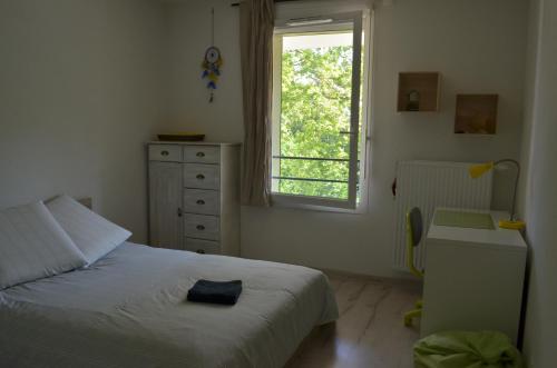 a bedroom with a bed and a window and a dresser at Aiko&Moi in Annecy